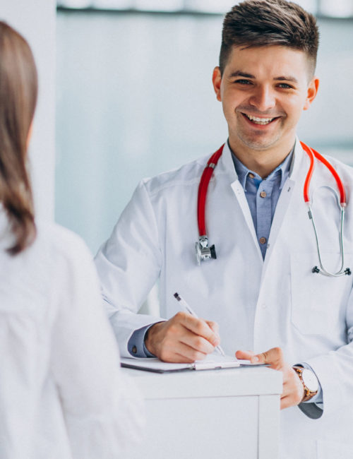 Young male psysician with patient at hospital