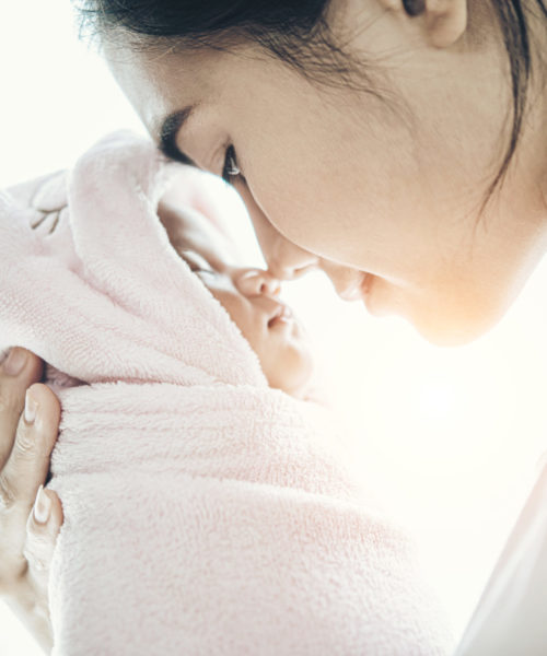 The newborn baby sleeping in the hands of the mother and the nose collided.